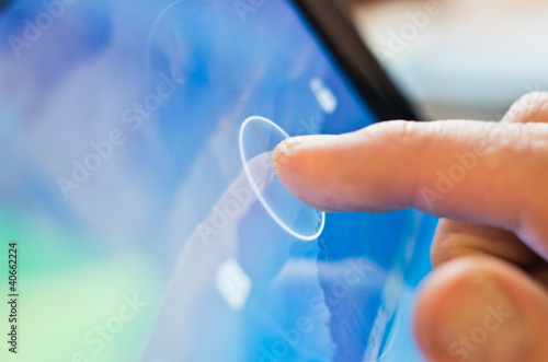 Foto: finger touching tablet device finger touching tablet device