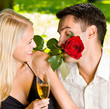 Couple with glasses of champagne and rose, outdoors