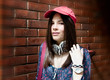 Photo: Beautiful urban girl posing over brick wall Beautiful urban girl posing over brick wall