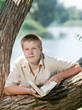 schoolchildren with the book in park on the bank of lake.. schoolchildren with the book in park on the bank of lake..