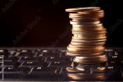 Photo: a coin pile over a keyboard a coin pile over a keyboard