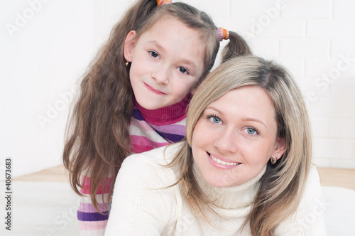 Photo: Smiling young mother and her daughter having fun at home Smiling young mother and her daughter having fun at home