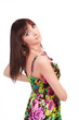Woman in a bright summer dress posing against white background