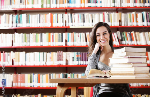 Photo: Portrait of a student girl studying at library Portrait of a student girl studying at library
