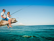 Fishing team - little girl fishing with father at the beach