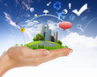Human hand holding a green landscape
