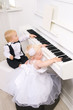 boy and girl playing on a white piano boy and girl playing on a white piano