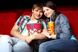Foto: Young couple in cinema watching movie Young couple in cinema watching movie