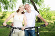 Photo: Young couple on the bikes in the park Young couple on the bikes in the park
