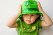 Photo: Pretty little girl tries on a fancy hat for St. Patrick's Day Pretty little girl tries on a fancy hat for St. Patrick's Day