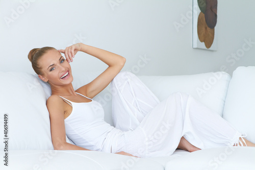 Photo: Young beautiful woman sitting on couch Young beautiful woman sitting on couch