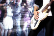 Young guitar player performing in night club