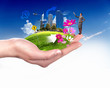 Human hand holding a green landscape