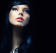 Beautiful Brunette Girl over Black Background. Darkness