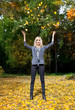 Young woman throwing leaves in the air