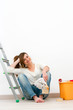 Photo: Young woman painter sitting on floor after painting. Young woman painter sitting on floor after painting.