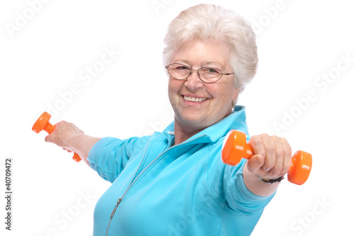 Photo: Senior woman working with weights in gym Senior woman working with weights in gym