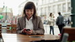 Happy young woman using smartphone in the city, steadicam shot