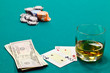 a glass of liquor and cards and dollars