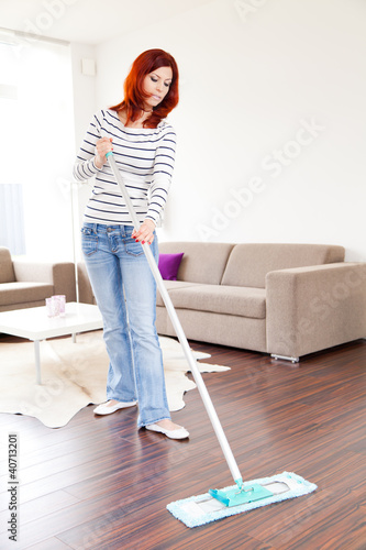Foto: Junge rothaarige Frau bei der Hausarbeit Junge rothaarige Frau bei der Hausarbeit