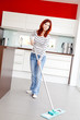 Foto: Junge rothaarige Frau bei der Hausarbeit Junge rothaarige Frau bei der Hausarbeit
