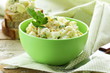 egg salad in a green cup with black bread