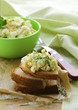 egg salad in a green cup with black bread