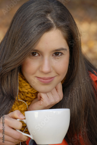 Photo: Joven mujer bebiendo café en otoño. Joven mujer bebiendo café en otoño.