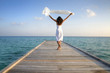Sexy happy woman in white clothes standing on a jetty (Maldives)