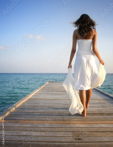Photo: Sexy happy woman in white clothes standing on a jetty (Maldives) Sexy happy woman in white clothes standing on a jetty (Maldives)