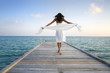 Sexy happy woman in white clothes standing on a jetty (Maldives)
