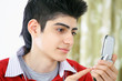 Photo: Text messaging teenage boy with mobile phone Text messaging teenage boy with mobile phone
