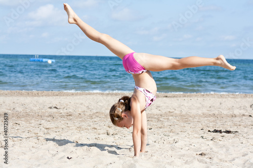 Photo: Mädchen macht Handstand mit Spagat Mädchen macht Handstand mit Spagat