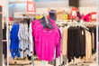 Variety of bright cardigans on stands in mall
