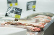 Fresh raw fish lie on table with ice in supermarket