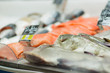 Fresh red sliced fish lie on table with ice in supermarket