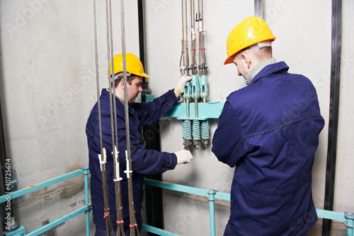 Photo: machinists adjusting lift in elevator hoistway machinists adjusting lift in elevator hoistway