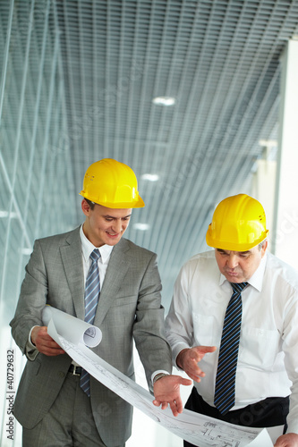 Photo: Discussing blueprint Discussing blueprint