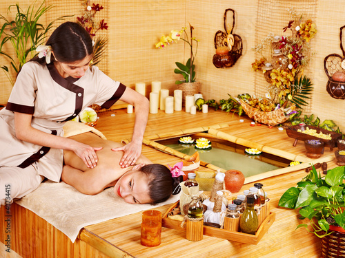 Photo: Woman getting massage in bamboo spa. Woman getting massage in bamboo spa.