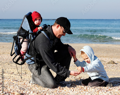 Photo: Dad, son and daughter during a walk along the sea Dad, son and daughter during a walk along the sea
