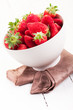 Strawberries inside bowl on white table Strawberries inside bowl on white table