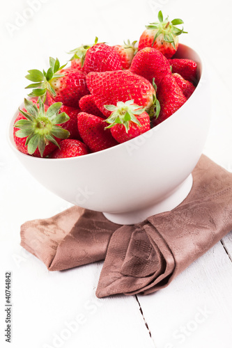 Photo: Strawberries inside bowl on white table Strawberries inside bowl on white table