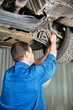Foto: auto mechanic at car suspension repair work auto mechanic at car suspension repair work