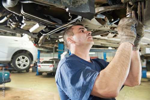 Photo: auto mechanic at car suspension repair work auto mechanic at car suspension repair work