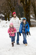 Mother Walking Two Children To School Along Snowy Street In Ski Mother Walking Two Children To School Along Snowy Street In Ski