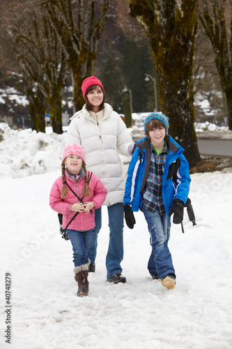 Photo: Mother Walking Two Children To School Along Snowy Street In Ski Mother Walking Two Children To School Along Snowy Street In Ski