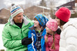 Portrait Of Family Wearing Winter Clothes In Snowy Landscape