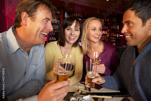 Foto: Group Of Friends Enjoying Sushi In Restaurant Group Of Friends Enjoying Sushi In Restaurant