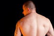 Muscular shirtless male standing with his back to the camera