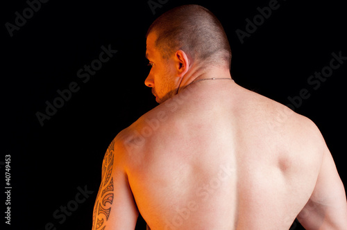 Foto: Muscular shirtless male standing with his back to the camera Muscular shirtless male standing with his back to the camera
